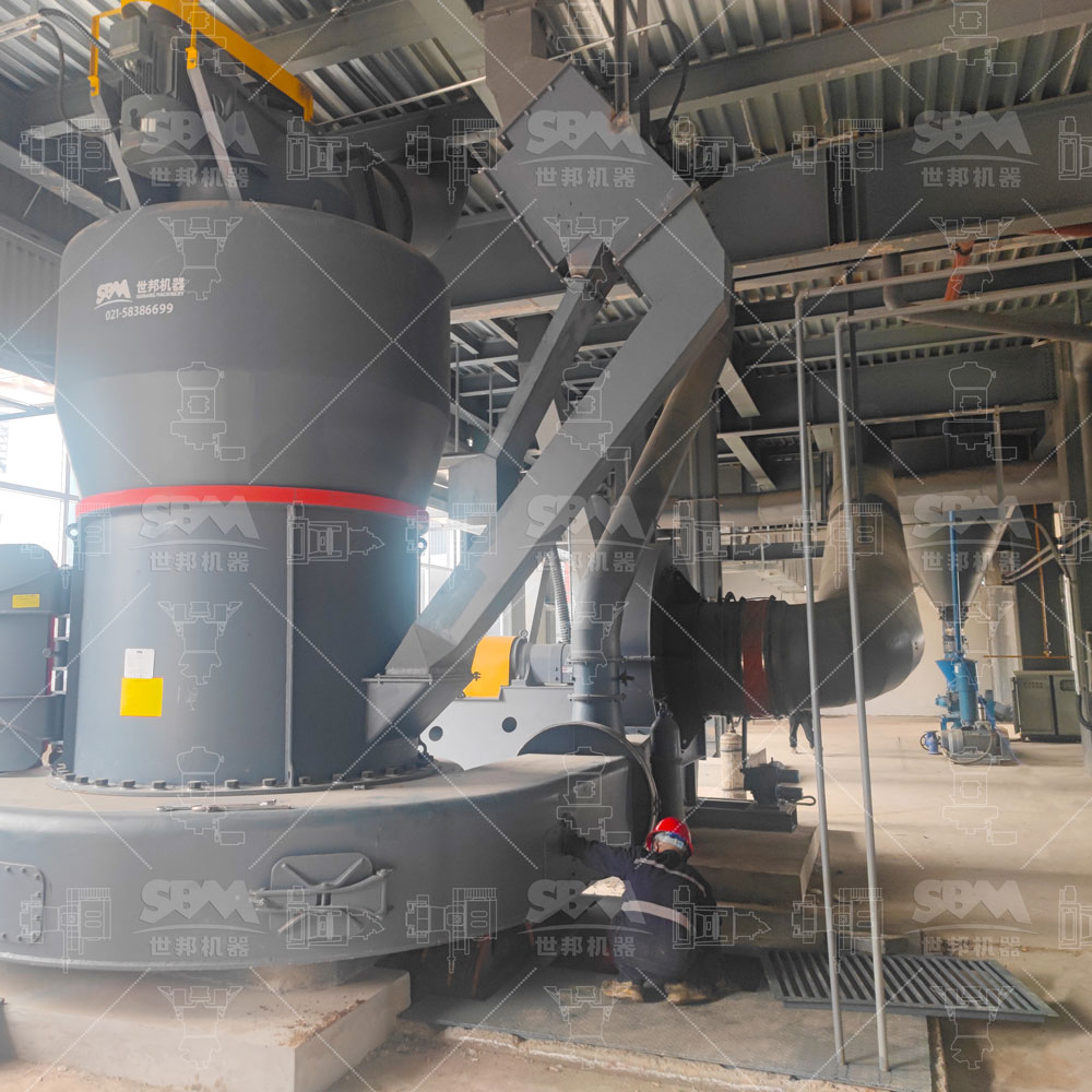 Operator monitoring a fully automated grinding mill control system with real-time data displays